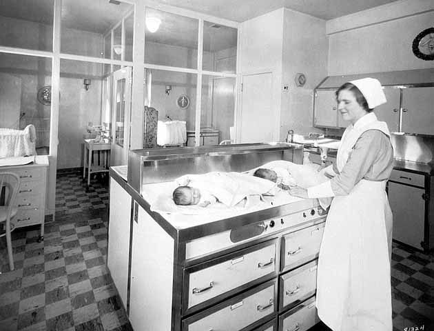 Two infants and nurse in obstretrics department - 1930